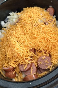 a crock pot filled with cheese and hot dogs