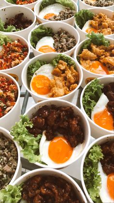 many bowls filled with different types of food on top of each other and one has an egg in the middle