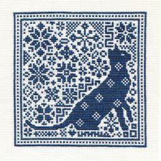 a cross stitch pattern with the silhouette of a dog on it's back, in blue and white