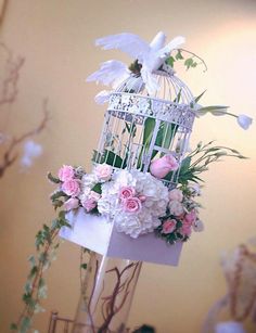 a birdcage with flowers and birds in it