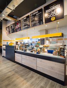 the inside of a fast food restaurant with menus on the wall and wood flooring