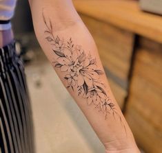 a woman's arm with a flower tattoo on the left side of her arm