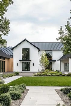 a white house with lots of windows and grass