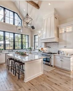 a large kitchen with white cabinets and wooden floors