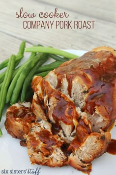 slow cooker company pork roast on a white plate with green beans