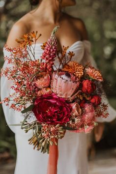 a woman holding a bouquet of flowers in her hands