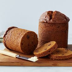 two loafs of bread on a cutting board with one sliced and the other half eaten