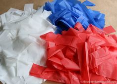 some red, white and blue tissue paper are on the table together to make an origami sculpture