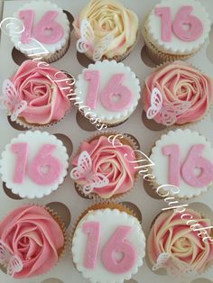 cupcakes decorated with pink and white frosting in the shape of roses are displayed