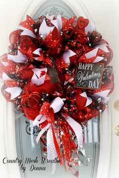 a red and white valentine's day wreath on the front door