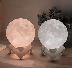 two moon lamps sitting next to each other on a table