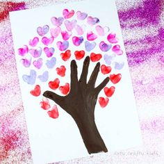 a handprinted tree with hearts is shown on a piece of paper that has been colored