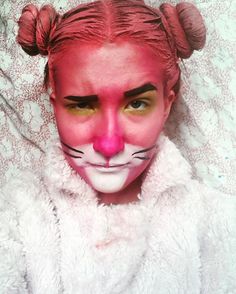 a woman with pink makeup and cat ears on her face