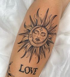 a sun tattoo with the word love written on it's arm and eyes closed