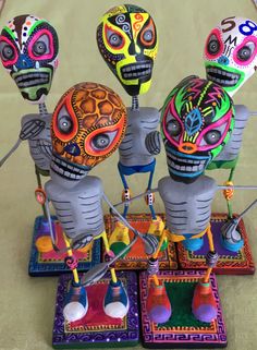 three colorfully painted sugar skulls sitting on top of each other in front of a table