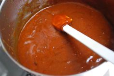 a spoon in a pot filled with sauce