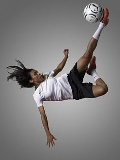 a man is jumping in the air with a soccer ball on his head and legs