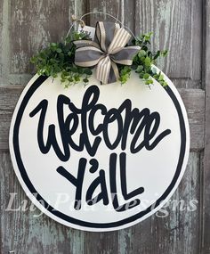 a welcome sign hanging on the side of a wooden door that says, welcome y'all