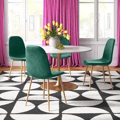 a dining room with pink curtains, blue chairs and a white table in the center