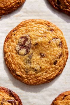 several chocolate chip cookies sitting on top of parchment paper