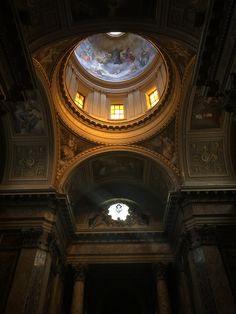 the inside of a building with an ornate ceiling and stained glass window above it,