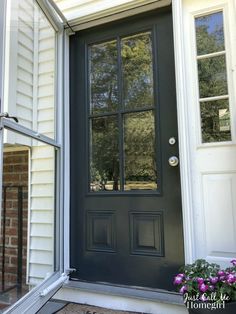 a black front door with two sidelights and glass panes on the top half