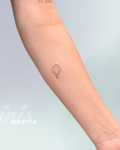 a person's arm with a small hot air balloon tattoo on it