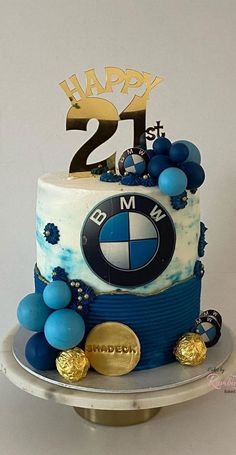 a birthday cake decorated with blue and white icing, gold decorations and the number 21 on top