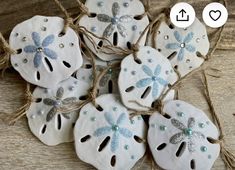 some sand dollars are tied up with twine and beads to make them look like sand dollar ornaments