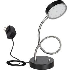 a desk lamp that is plugged in to a charger on a white background