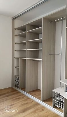 an empty walk in closet with shelves and baskets on the floor next to a sink