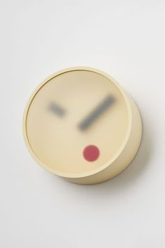 a round object with a face drawn on it's side and red dots in the middle