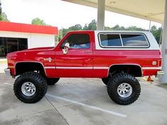 a red truck parked in front of a gas station