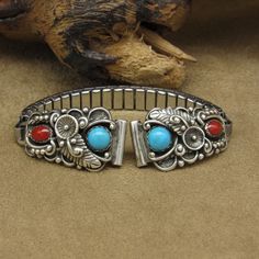 Ladies sterling silver watch band with turquoise and coral. The tips are 1 1/4" long and 5/8" wide. The tubes which hold the pins are 7/16" wide. The stretch band is 2 7/8" long. The back is stamped STC Sterling USA. The turquoise is 5mm in diameter. The oval coral is 6mm long. Leaves, flowers, scrolls, and silver beads make the design. The band is in good condition. Thank you for shopping in our store. Please let us know if you have questions. MS-21 k *The color you see on your screen may not r Turquoise And Coral, Stretch Band, Stretch Bands, Ladies Watch, How To Make Beads, Silver Watch, Watch Band, Silver Beads, Accessories Watches