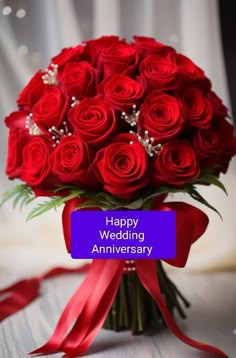 a bouquet of red roses with the words happy wedding anniversary