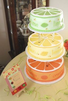 three tiered cake sitting on top of a table next to a small card board