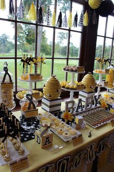 a table filled with desserts and cupcakes in front of a large window