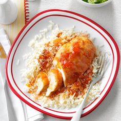 a white plate topped with rice and meat covered in sauce