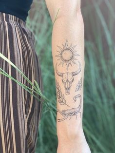 a person with a tattoo on their arm holding a green plant in front of him