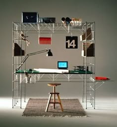 a computer desk sitting on top of a wooden stool