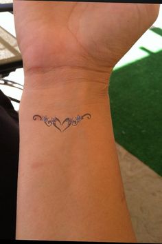 a woman's wrist with a small tattoo on it