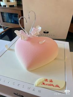 a pink heart shaped pillow sitting on top of a box