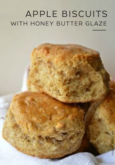 three apple biscuits with honey butter glaze stacked on top of each other in a white paper towel