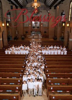 a large group of children in white shirts and khakis are standing in front of rows of pews