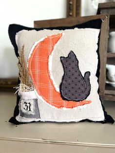 a decorative pillow with a cat on the front and number 13 on the back, sitting on a table