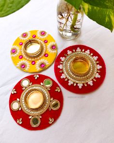 three decorative coasters sitting on top of a table next to a potted plant