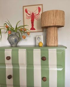 a green and white dresser with a lamp on top