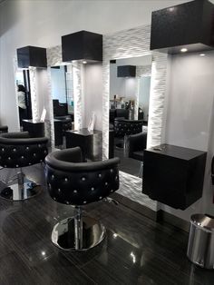 a hair salon with black chairs and mirrors