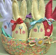 three stuffed bunnies in a basket on a table