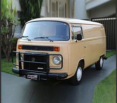 an old van is parked on the side of the road in front of a house